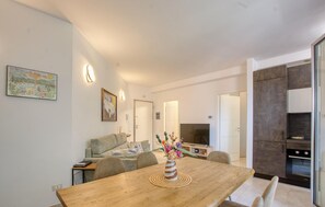 Eine moderne Küche mit Essbereich, einer Couch und einem Gemälde an der Wand.