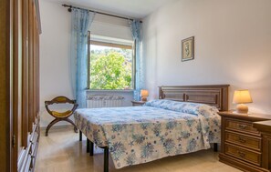 A bedroom with a bed, bedside lamps, a dresser, a window with curtains, and a picture on the wall. - 1 bedroom lovely apartment in Rapallo (Rapallo)