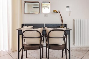 Una stanza moderna con una scrivania, due sedie, una lampada e un termosifone.