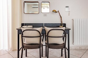 Una stanza moderna con una scrivania, due sedie, una lampada e un termosifone.