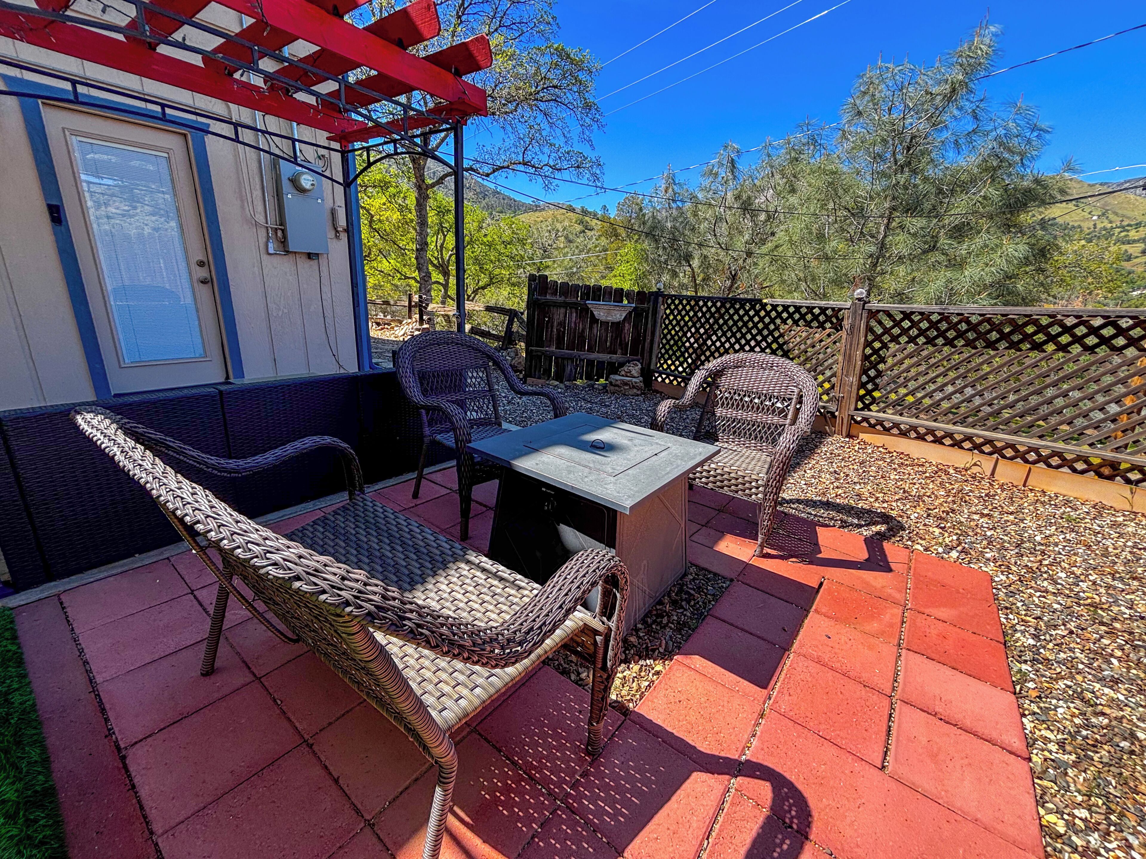 An outdoor patio with wicker furniture, a table, and a red pergola.
