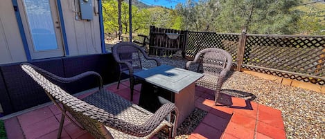An outdoor patio with wicker furniture, a table, and a red pergola.