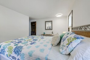 A bedroom with a bed, a bedside table, a mirror, and a window with blinds. - Sea Breeze, Sunset Views! Family Escape Near Ocean (Wellfleet)
