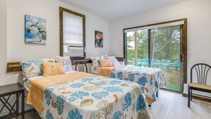 Ein Zimmer mit zwei Betten, einem Fenster und Blick ins Freie.