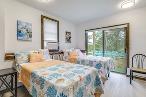 Ein Zimmer mit zwei Betten, einem Fenster und Blick ins Freie.