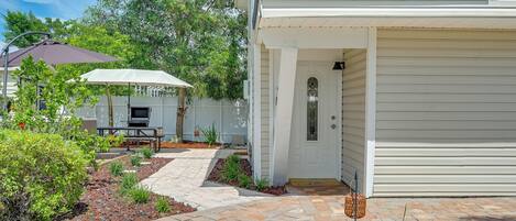 A residential property with a covered patio, a barbecue area, and a landscaped garden.