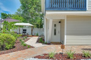 Um imóvel residencial com varanda coberta, espaço para churrasco e jardim ajardinado.