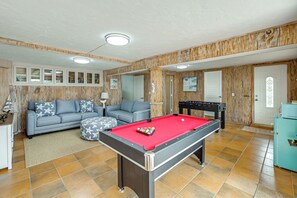 A room with a pool table, a sofa, and a foosball table. - Island Oasis w/ Hot Tub, Walk to Shops and Dining (Marco Island)