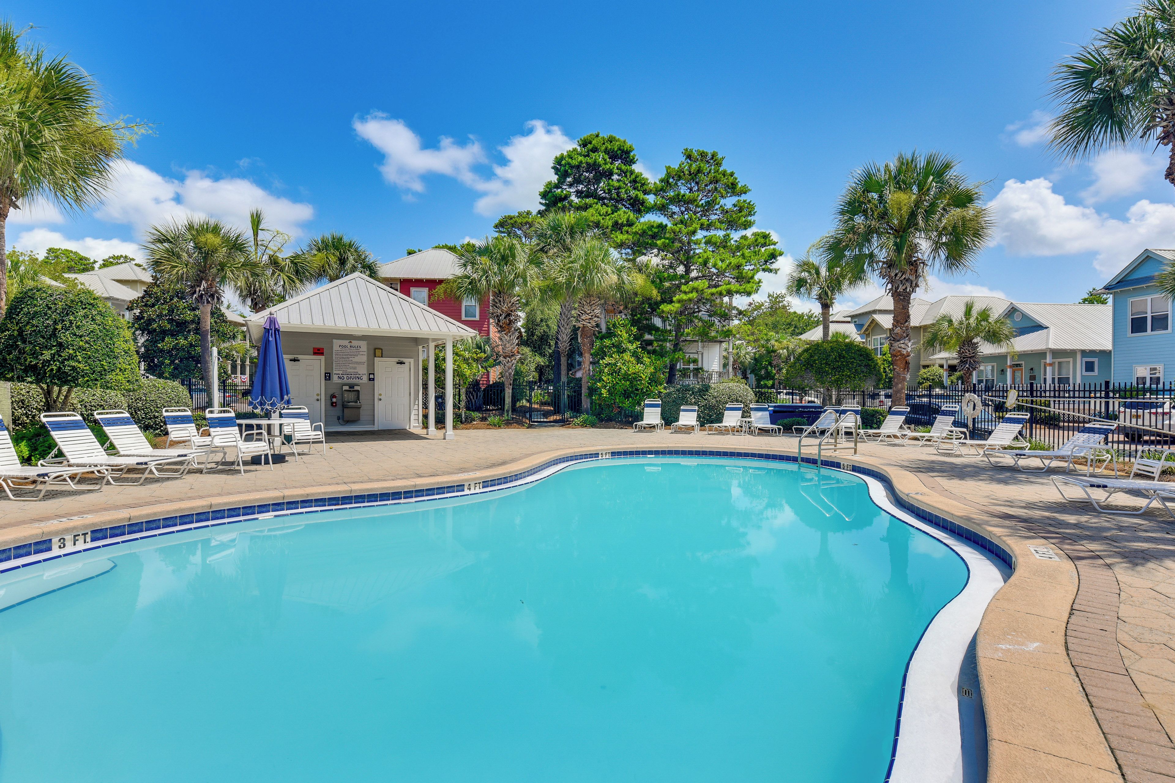 A swimming pool with lounge chairs and a gazebo.