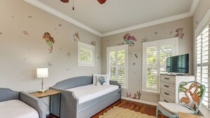 A bedroom with a bed, bedside tables, a TV, and decorative wall stickers. - Walkable 30A Beach House: 2 Community Pools, Bikes (Santa Rosa Beach)