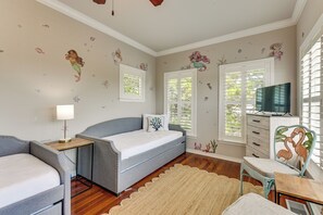 Ein Schlafzimmer mit Bett, Nachttischen, einem Fernseher und Wandstickern.