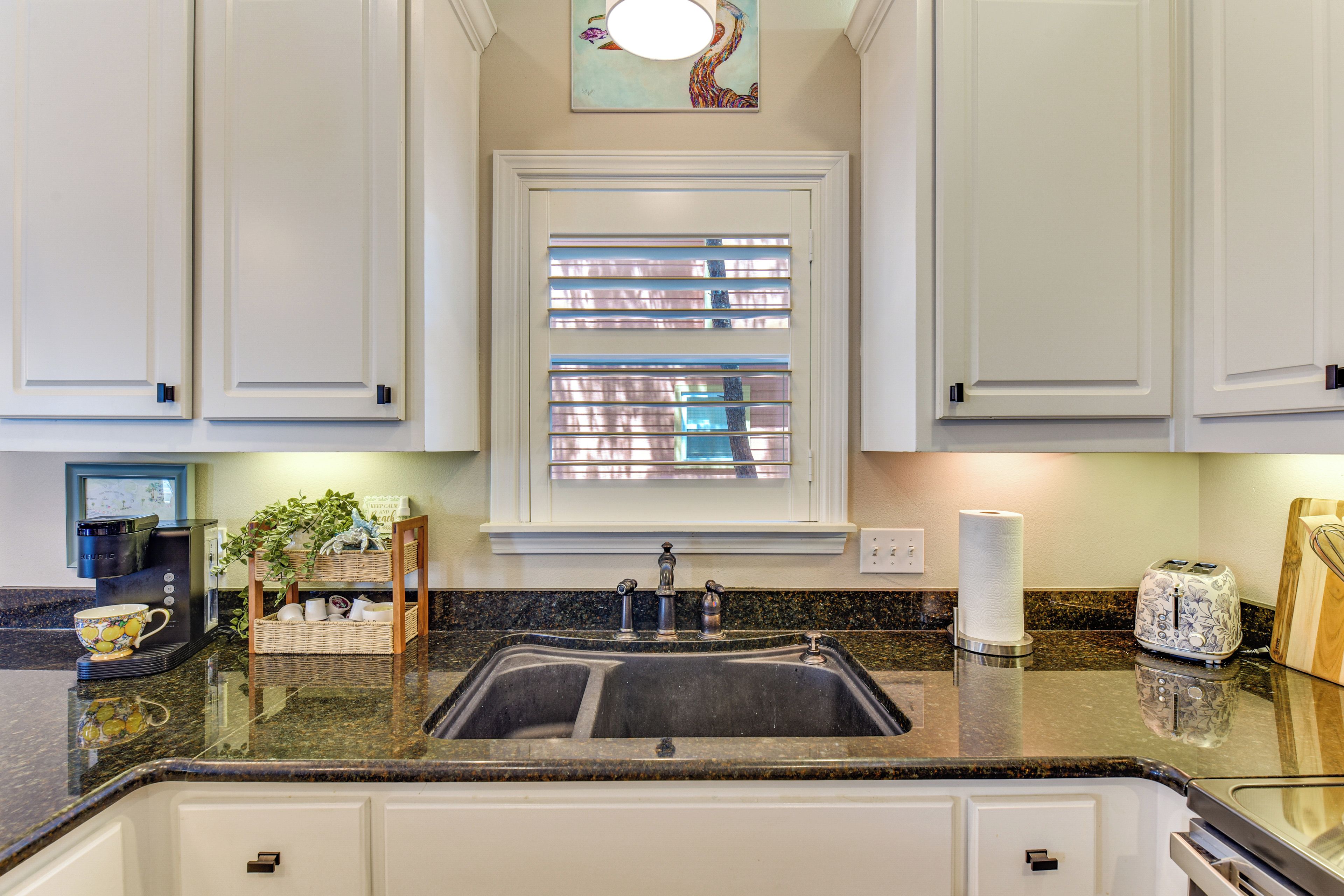 A kitchen with a built-in sink, a coffee maker, and a toaster on the counter.
