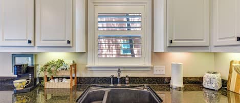 A kitchen with a built-in sink, a coffee maker, and a toaster on the counter.
