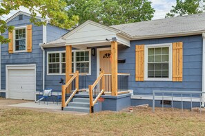 A two-story house with a front porch, a garage, and a small front yard.
