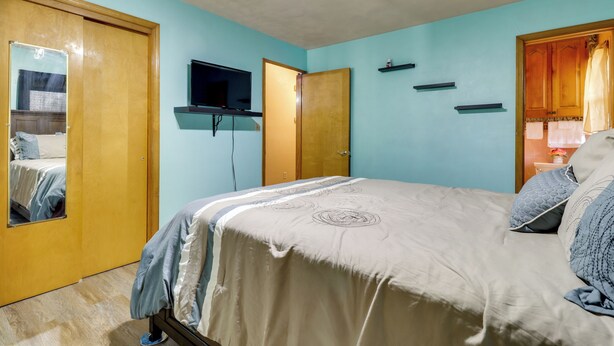 A bedroom with a bed, a television, and a wardrobe.