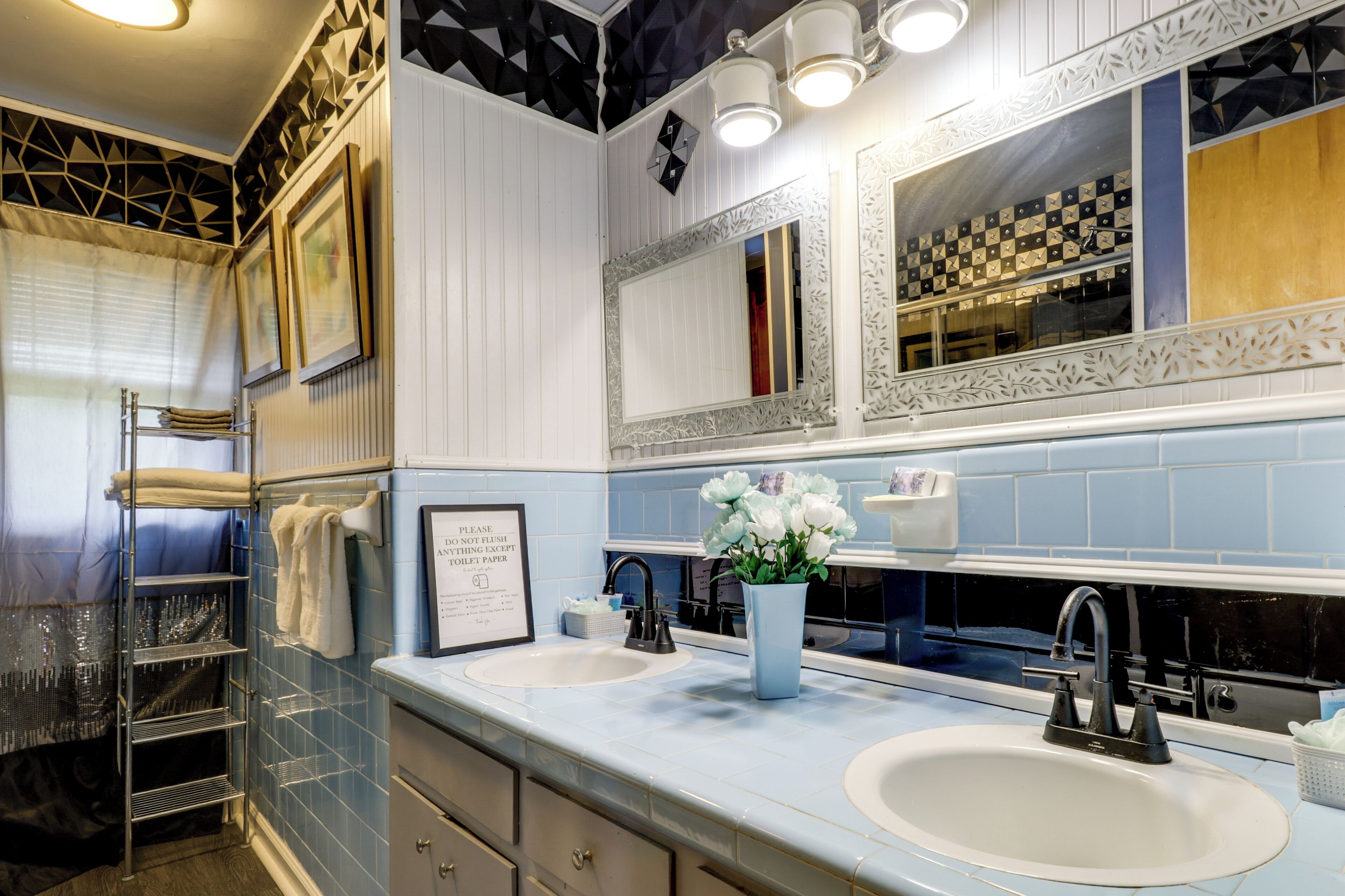 A bathroom with two sinks, a mirror, and a towel rack.