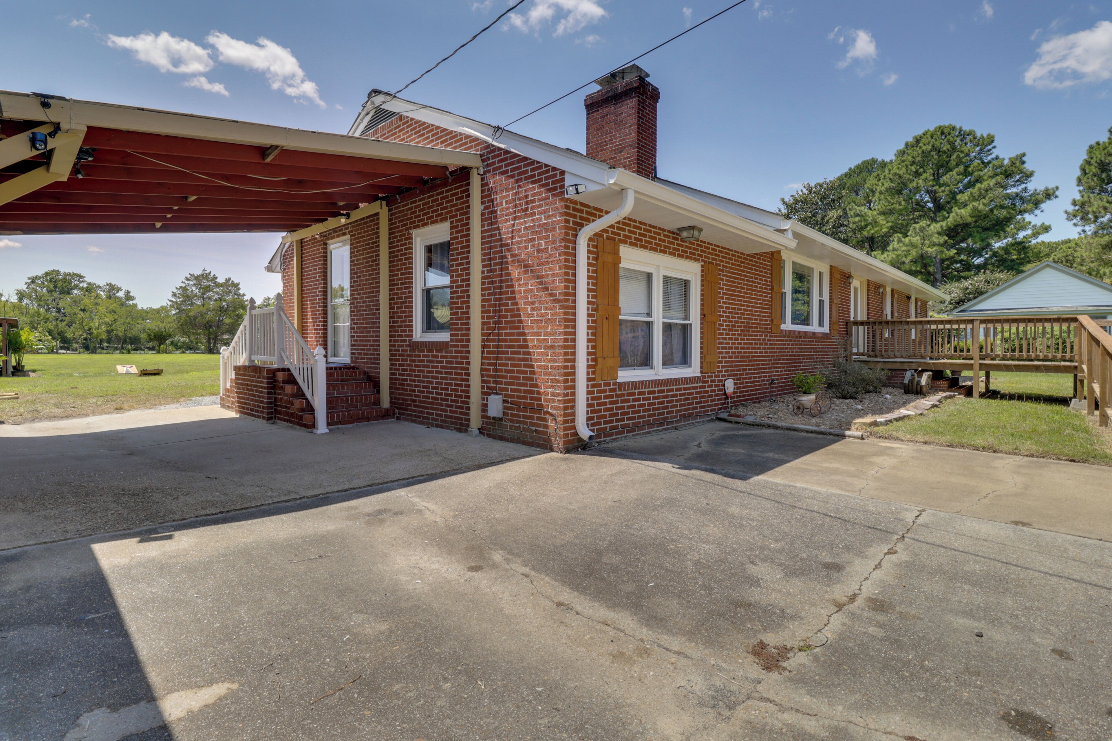A single-story brick house with a covered porch and a chimney.