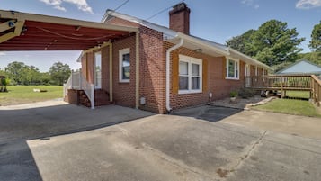 A single-story brick house with a covered porch and a chimney.