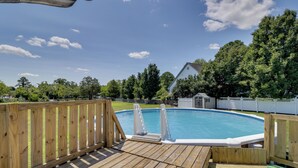 A wooden deck with a pool, surrounded by a white fence and trees. - Waterfront Family Home w/ Dock in Poquoson! (Poquoson)