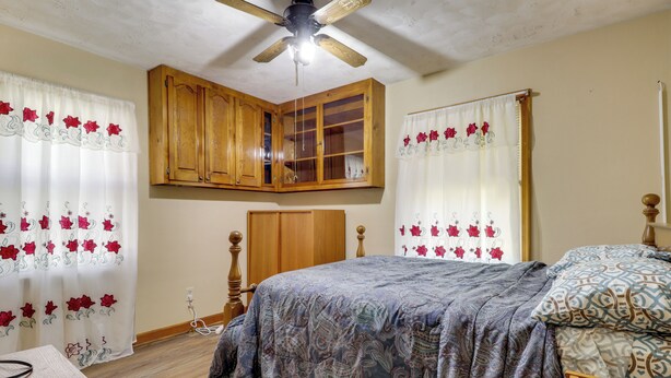 A bedroom with a bed, wooden wardrobe, and a ceiling fan. - Waterfront Family Home w/ Dock in Poquoson! (Poquoson)