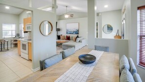 A modern kitchen with a dining area, a living room with a sofa and a coffee table, and a large window with blinds. - 4 Mi to River & Gardens! Quiet Port St Lucie Home (Port Saint Lucie)