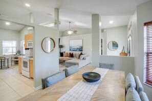 A modern kitchen with a dining area, a living room with a sofa and a coffee table, and a large window with blinds. - 4 Mi to River & Gardens! Quiet Port St Lucie Home (Port Saint Lucie)