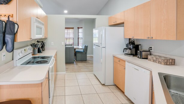 A modern kitchen with a stove, microwave, refrigerator, and a coffee maker. - 4 Mi to River & Gardens! Quiet Port St Lucie Home (Port Saint Lucie)