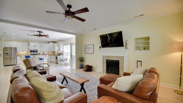 A spacious living room with leather sofas, a fireplace, and a television mounted above it. - 1 Block to Shore + Private Pool in Norfolk (Norfolk)