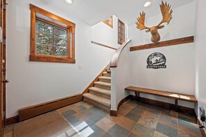 Eine Treppe mit hölzernem Geländer, einer Bank und einem an der Wand befestigten Moosbock-Wandbild.