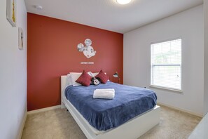 A bedroom with a bed, a window, and a wall with a Mickey Mouse poster. - Unwind Poolside, Explore Wdw! Kissimmee Retreat (Kissimmee)