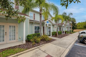 A row of single-story houses with front porches, a parking area, and a clear sky. - Unwind Poolside, Explore Wdw! Kissimmee Retreat (Kissimmee)