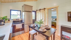 Una cucina con mobili in legno, un fornello e un'area pranzo con tavolo e sedie.