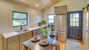 Una cucina moderna con soffitto in legno, elettrodomestici in acciaio inossidabile e vista sull'esterno.