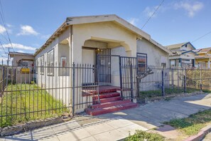 A residential building with a gated entrance, a porch, and a staircase leading to the main door. - Yard, Fireplace, Full Kitchen! Oakland Home (Oakland)