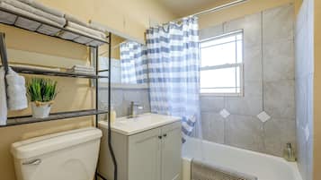 A bathroom with a toilet, sink, and shower area.