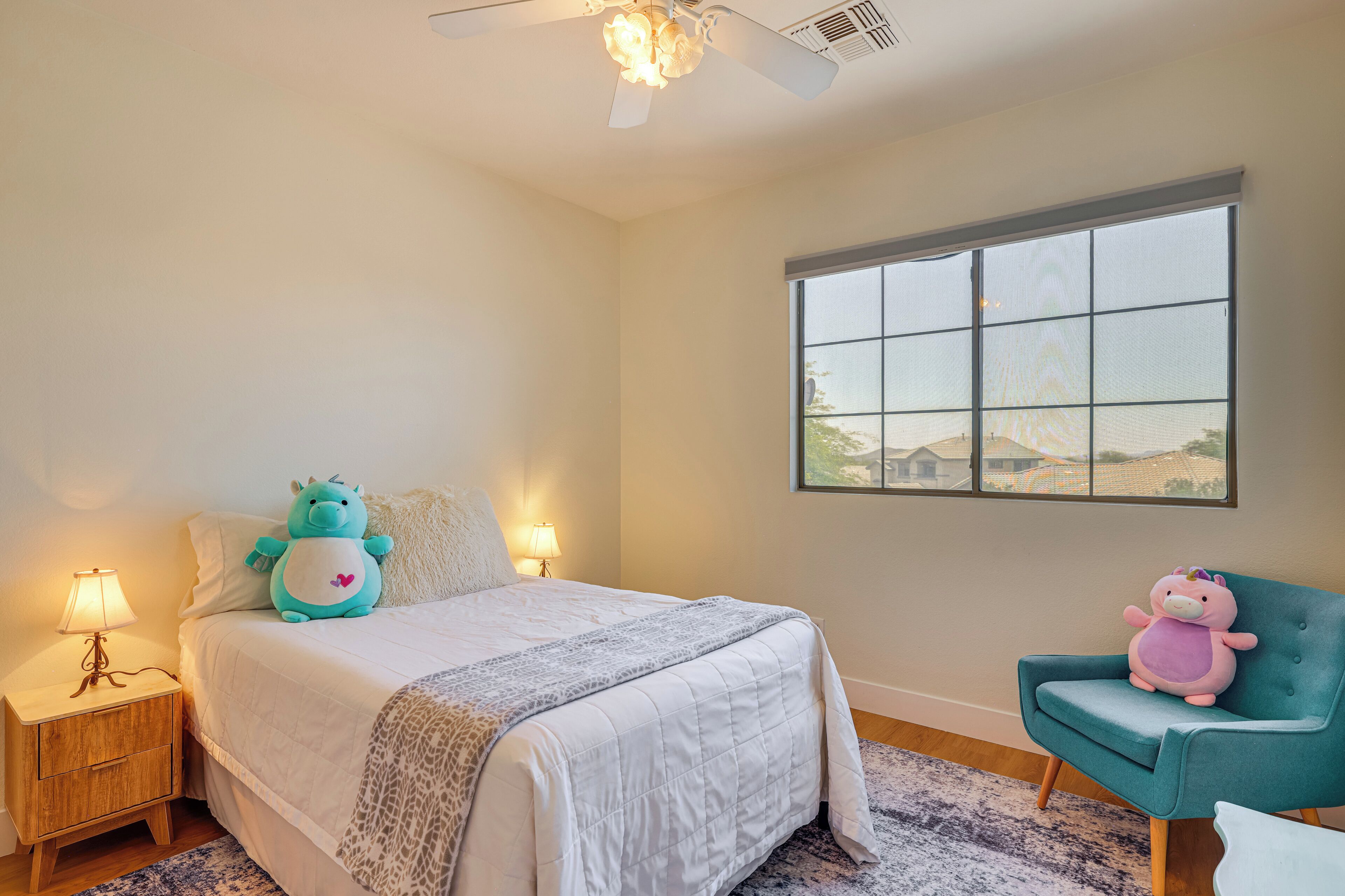 Un dormitorio con cama, dos mesitas de noche, una ventana y una silla.