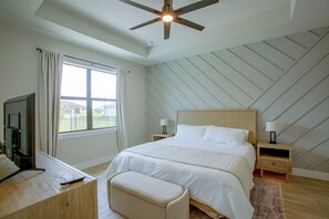 A bedroom with a bed, nightstands, a television, and a ceiling fan. - Poolside Paradise in Northwest Cape Coral! (Cape Coral)