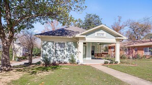 A single-story house with a front porch, a small attached garage, and a well-maintained lawn. - 1 Mi to Dtwn Tyler! Historic Retreat + Guest Suite (Tyler)