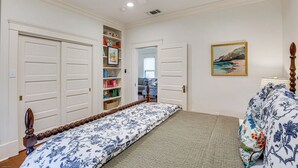 A bedroom with a bed, a bookshelf, a painting, and a door leading to another room. - 1 Mi to Dtwn Tyler! Historic Retreat + Guest Suite (Tyler)