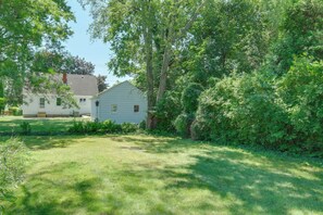 A residential property with a well-maintained lawn, two houses, and dense surrounding foliage. - Vintage MCM Charm Modern Comforts West Akron (Akron)