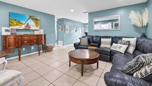 A living room with a sofa, coffee table, and a desk with a computer. - Bring Your Boat! Retreat 5 Mi to Crystal River (Homosassa)