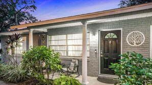 A residential house with a brick facade, a front porch with a chair, and a door with a tree decoration. - Bring Your Boat! Retreat 5 Mi to Crystal River (Homosassa)