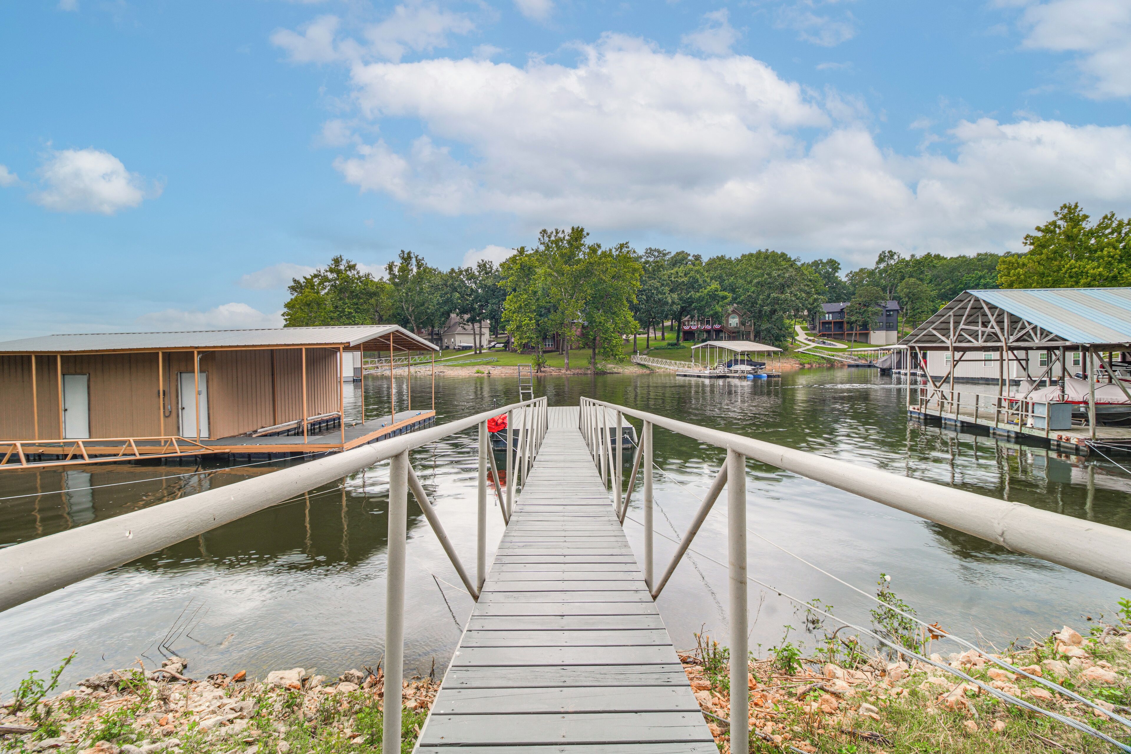 A wooden dock leading to a calm body of water with a clear sky above.