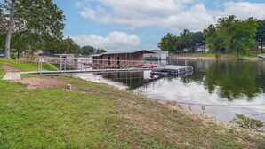 A lakeside building with a dock, surrounded by trees and a grassy area. - Honey Creek Cabin on Grand Lake w/ Private Dock! (Grove)