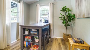 A room with a wooden table, a bookshelf, a potted plant, and a chessboard. - Honey Creek Cabin on Grand Lake w/ Private Dock! (Grove)