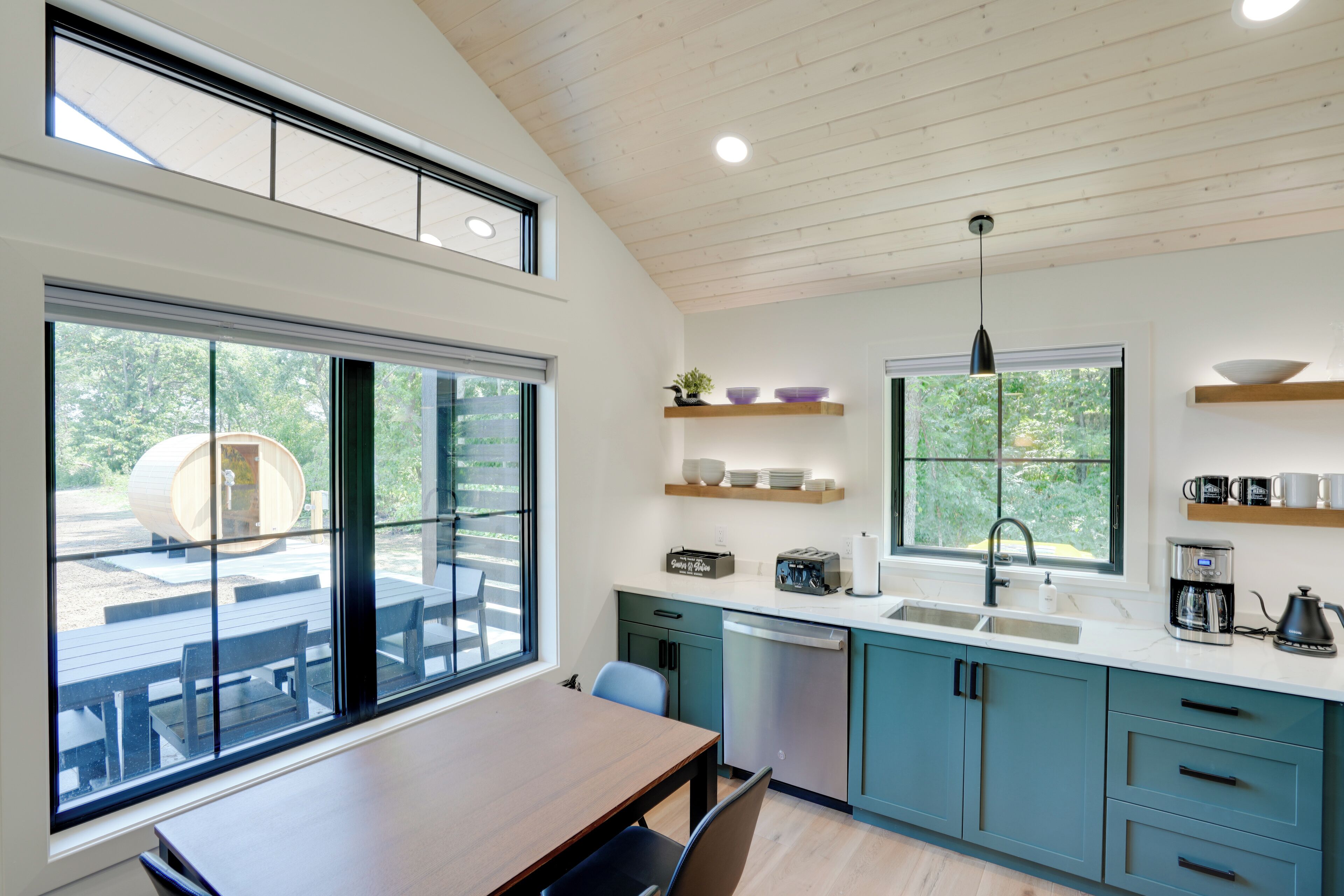 A modern kitchen with a large window, a dining area, and a built-in oven.