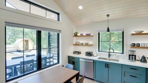 A modern kitchen with a large window, a dining area, and a built-in oven.