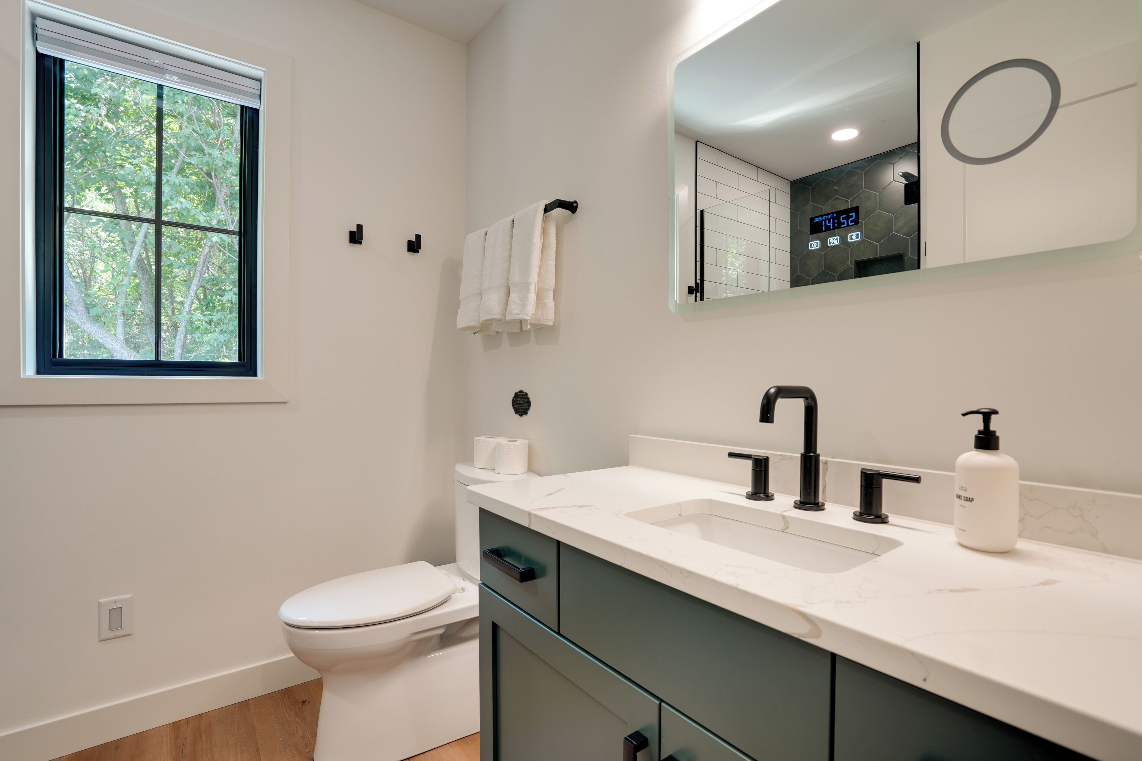 Un baño moderno con inodoro, lavamanos y espejo.