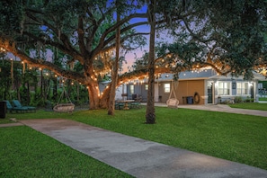 A well-maintained outdoor area with a pathway leading to a building, surrounded by trees and string lights. - 5 Mi to 3 Sisters Springs! Unit w/ Boat Parking (Homosassa)