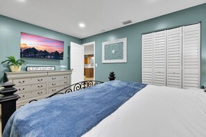 A bedroom with a bed, a dresser, a painting, a closet, and a door leading to another room. - 5 Mi to 3 Sisters Springs! Unit w/ Boat Parking (Homosassa)
